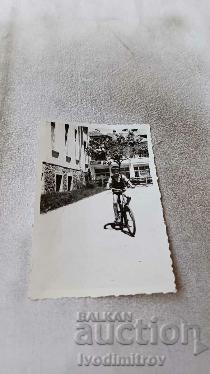 Foto Băiat cu o bicicletă de epocă pe stradă