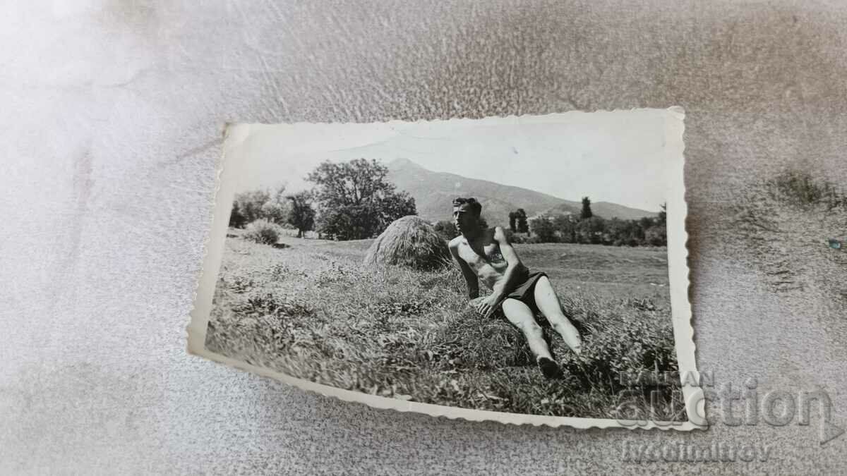 Photo A man in shorts lying on the grass