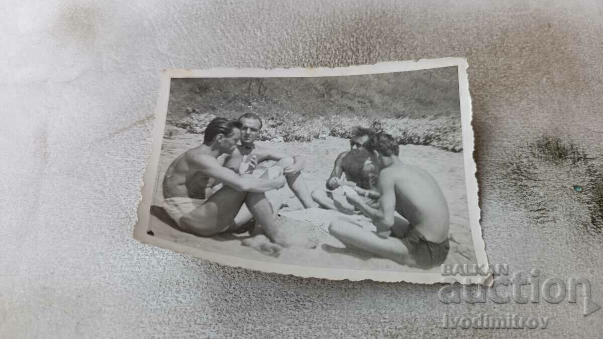 Снимка Четирима мъже играят карти на плажа