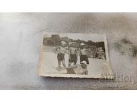 Fotografie Un bărbat și trei băieți în costume de baie vintage pe plajă
