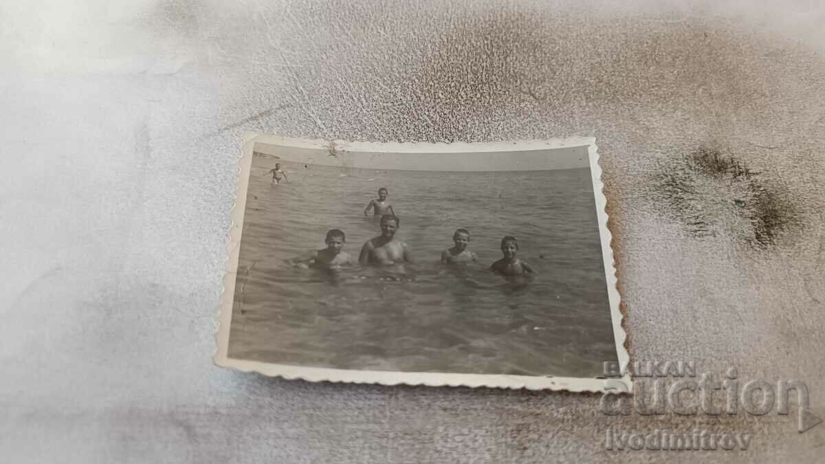 Photo Man and four boys in the sea