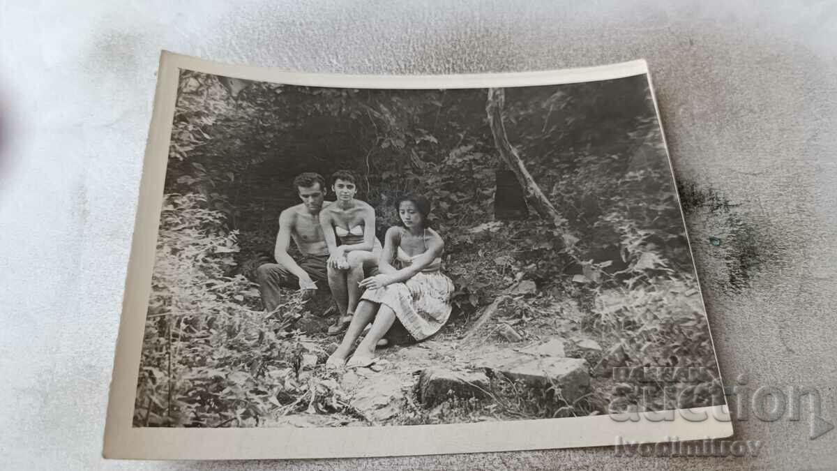 Photo A young man and two young girls in swimsuits in the forest