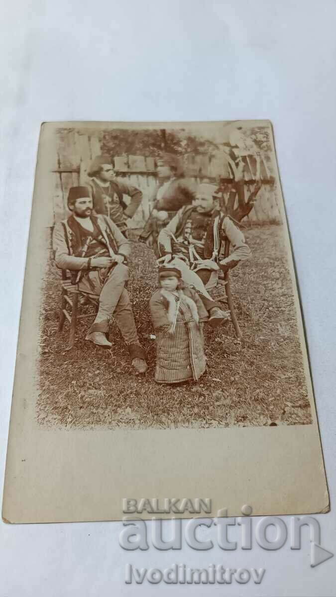 Foto Trei bărbați și o femeie în haine tradiționale