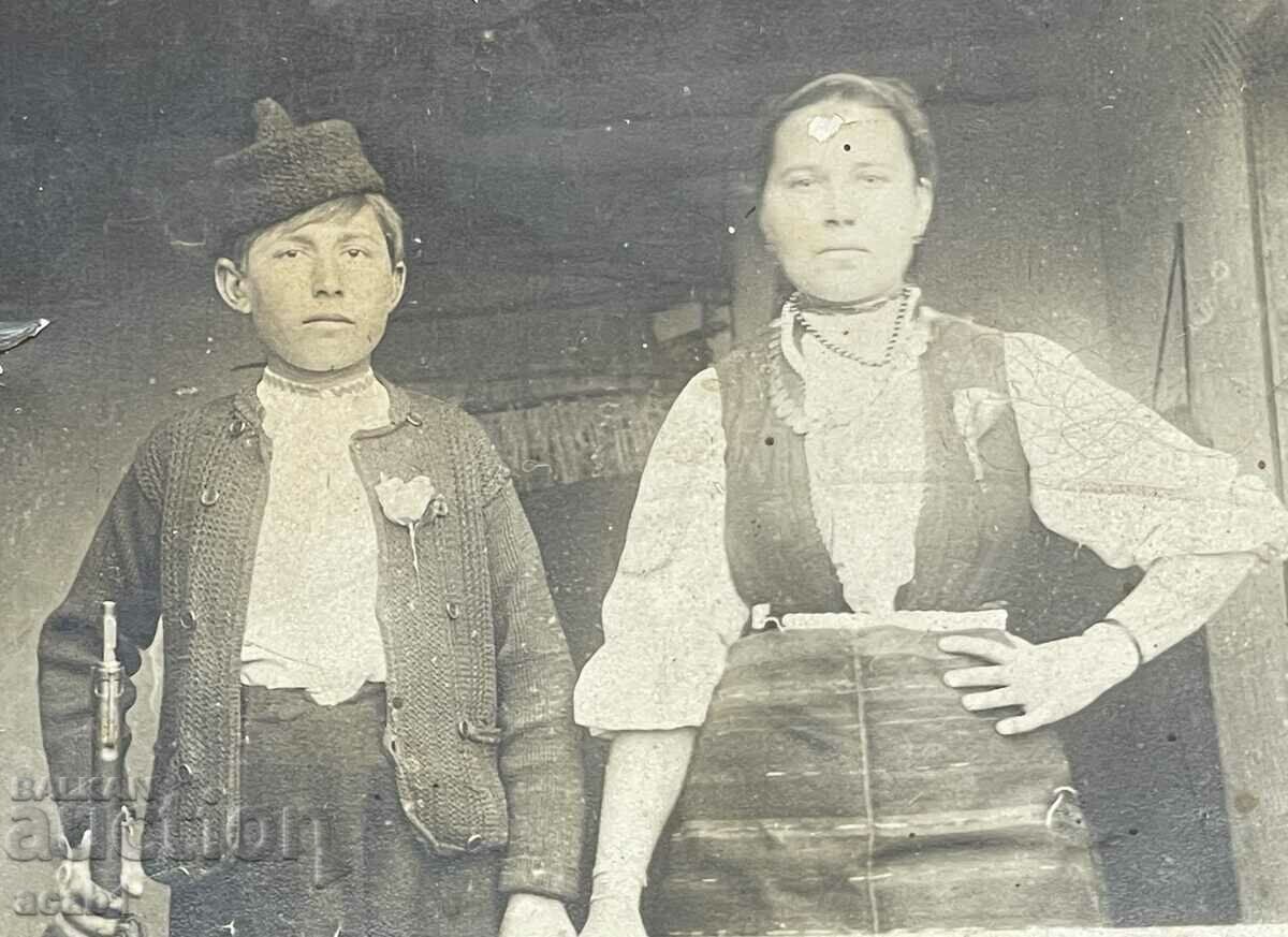 A boy with a rifle and his mother