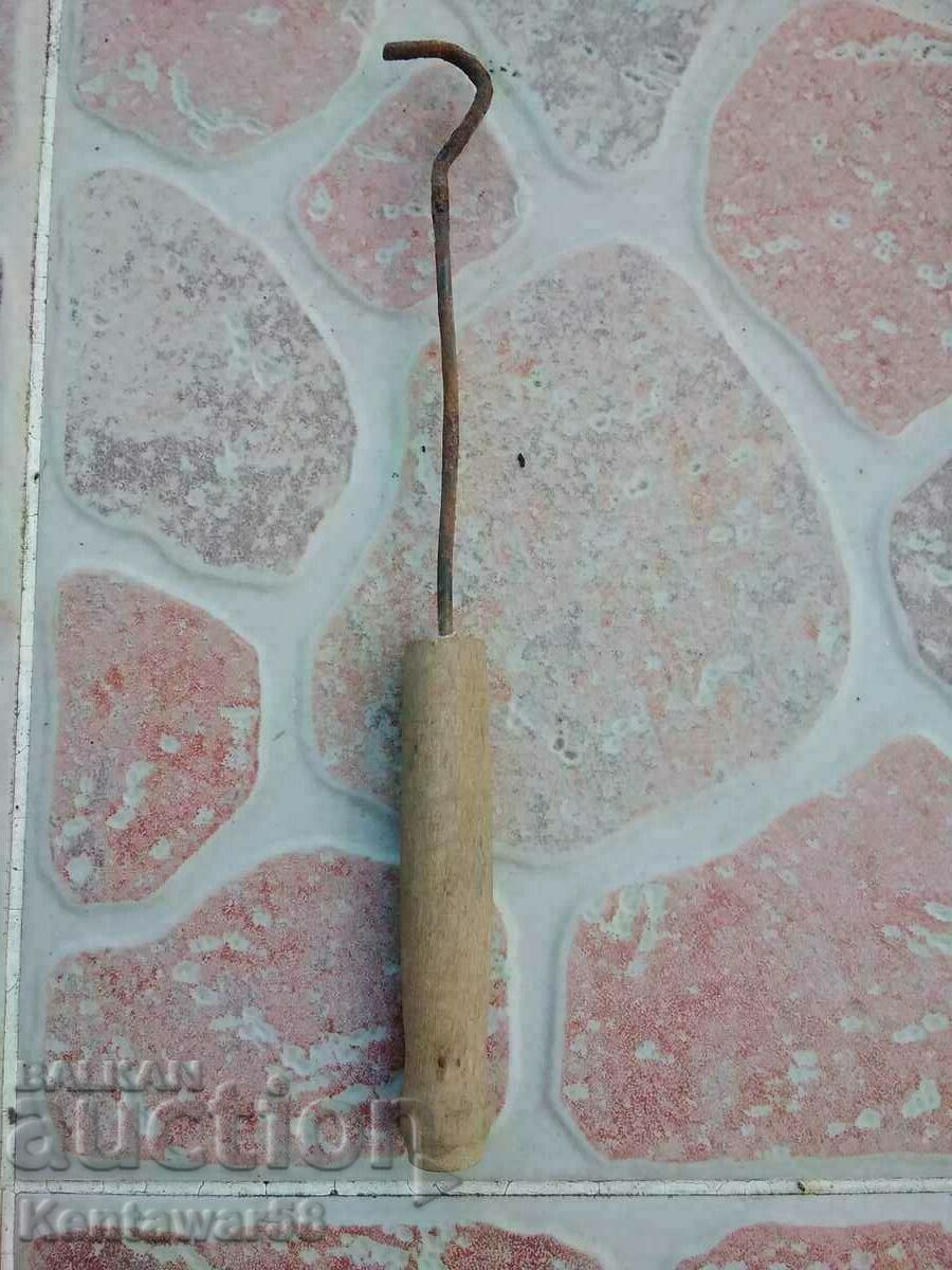An old hook with a wooden handle.
