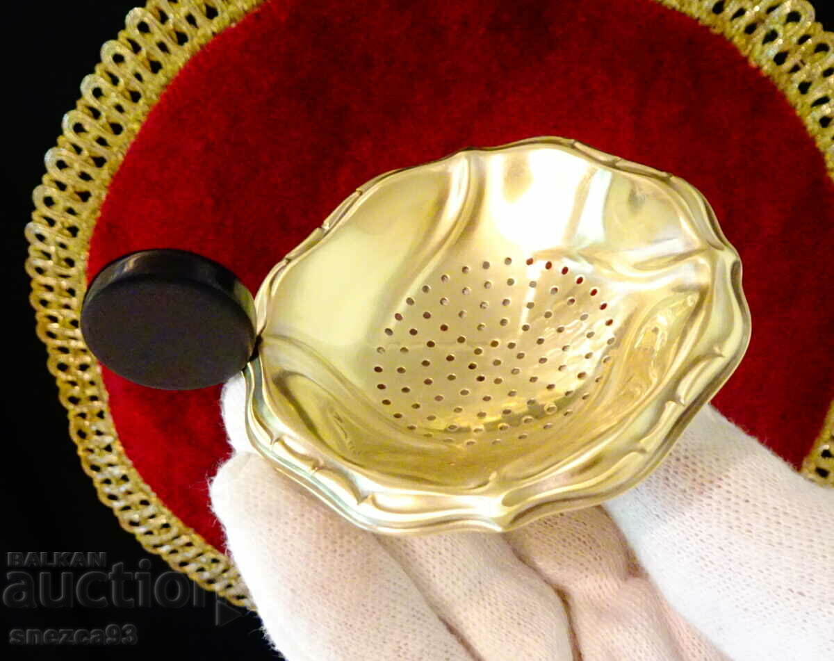 Brass tea strainer with cataline, baroque.