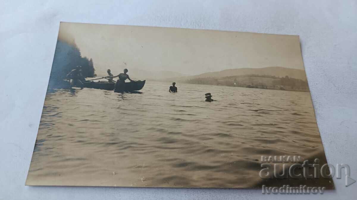 Φωτογραφία Νέοι άνδρες και γυναίκες με μια βάρκα στη θάλασσα