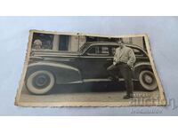 Φωτογραφία Ένας άνδρας μπροστά από ένα vintage αυτοκίνητο στο δρόμο