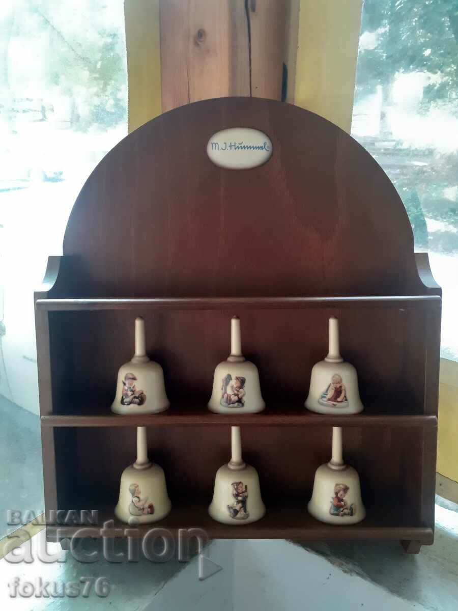 A collection of Goebel porcelain bells with a board