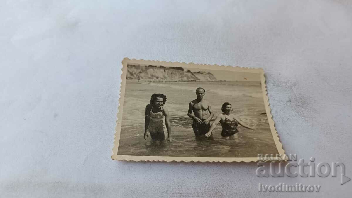 Photo A man and two women on the beach