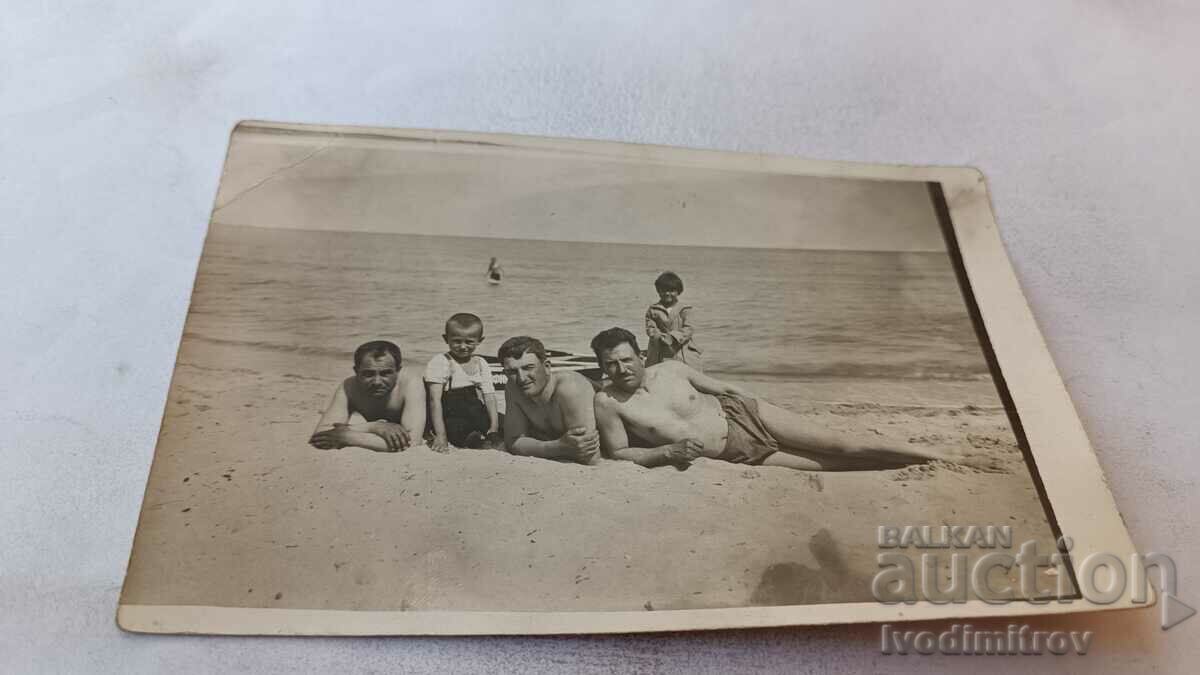 Photo Three men and two children on the beach