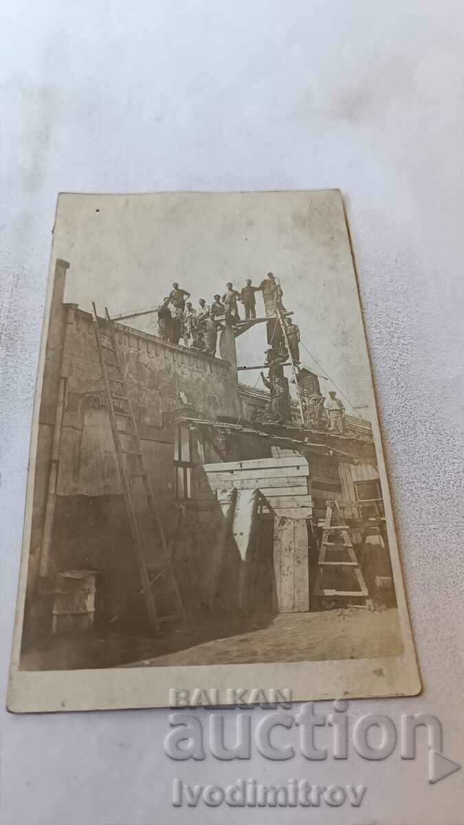 Foto Lucrători la construcția unei clădiri masive