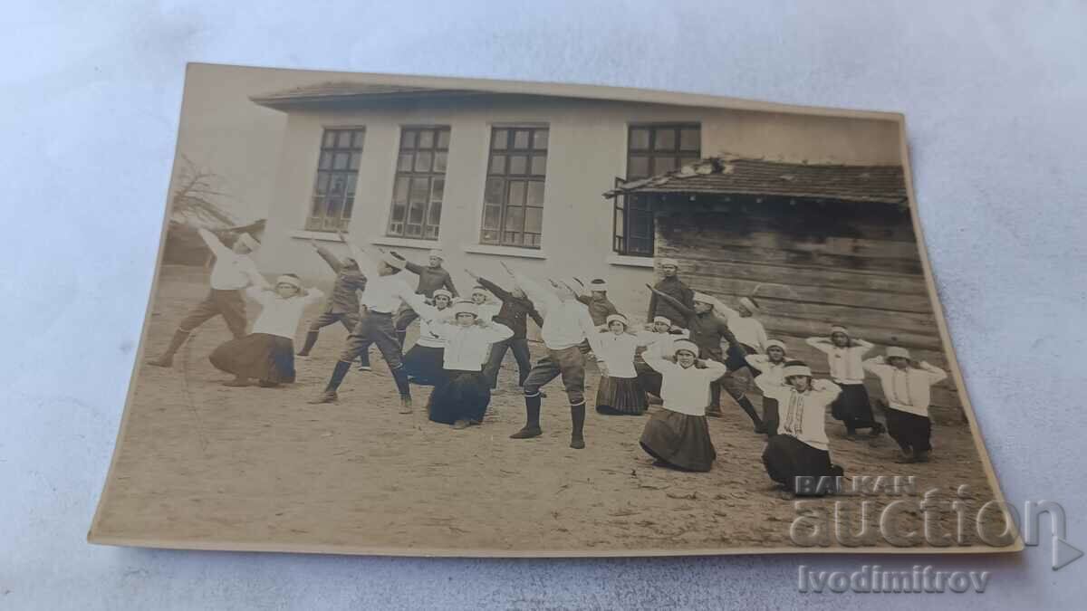 Doamna Elevii în șapcă băiețel fac exerciții în curte 1929