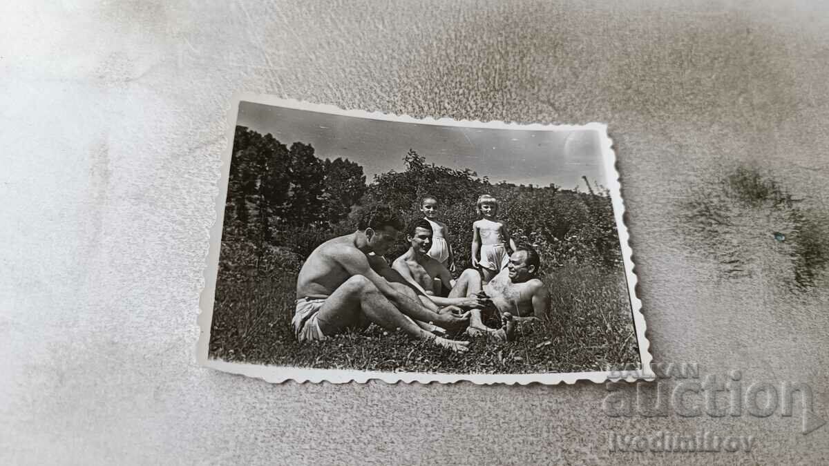 Photo Two men and children in shorts on the lawn