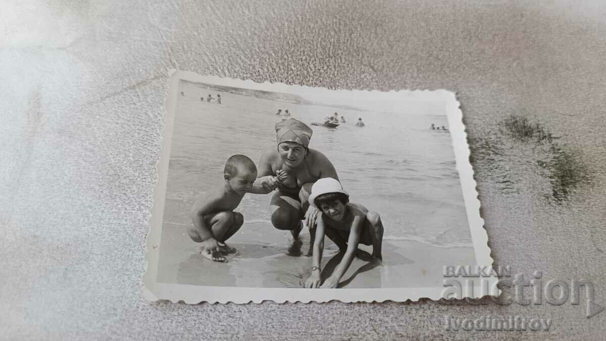 Снимка Жена и две малки деца на брега на морето