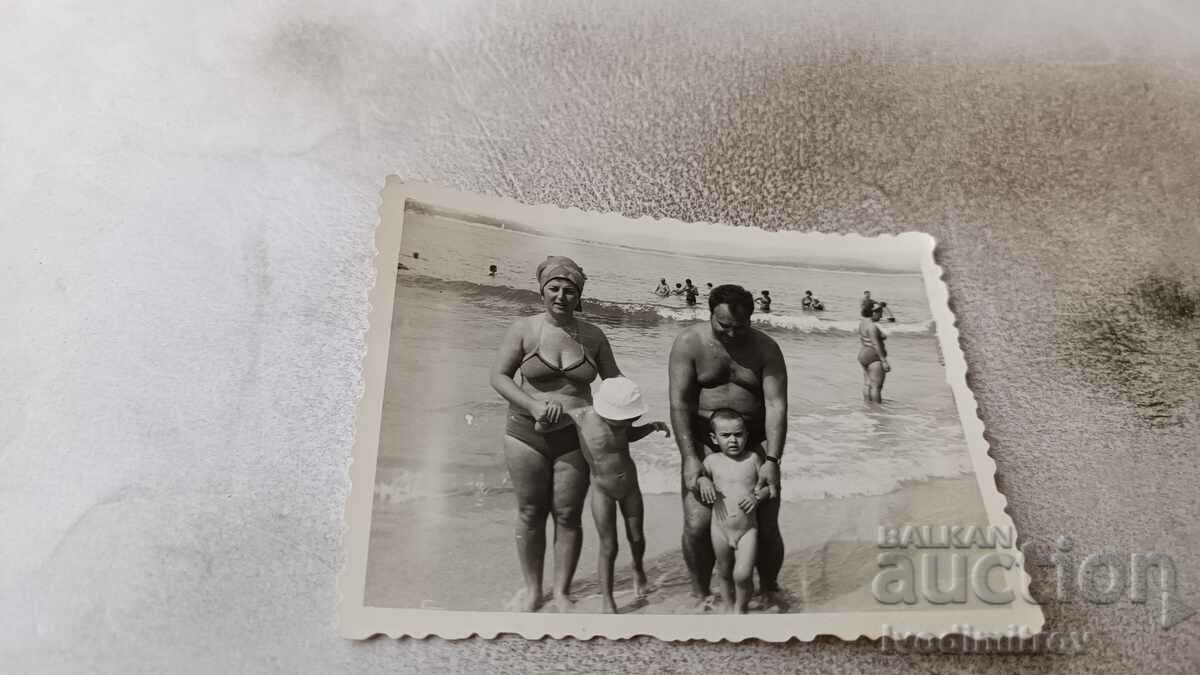 Fotografie Bărbat, femeie și doi copii mici pe plajă