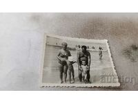 Φωτογραφία Άνδρας, γυναίκα και δύο μικρά παιδιά στην παραλία