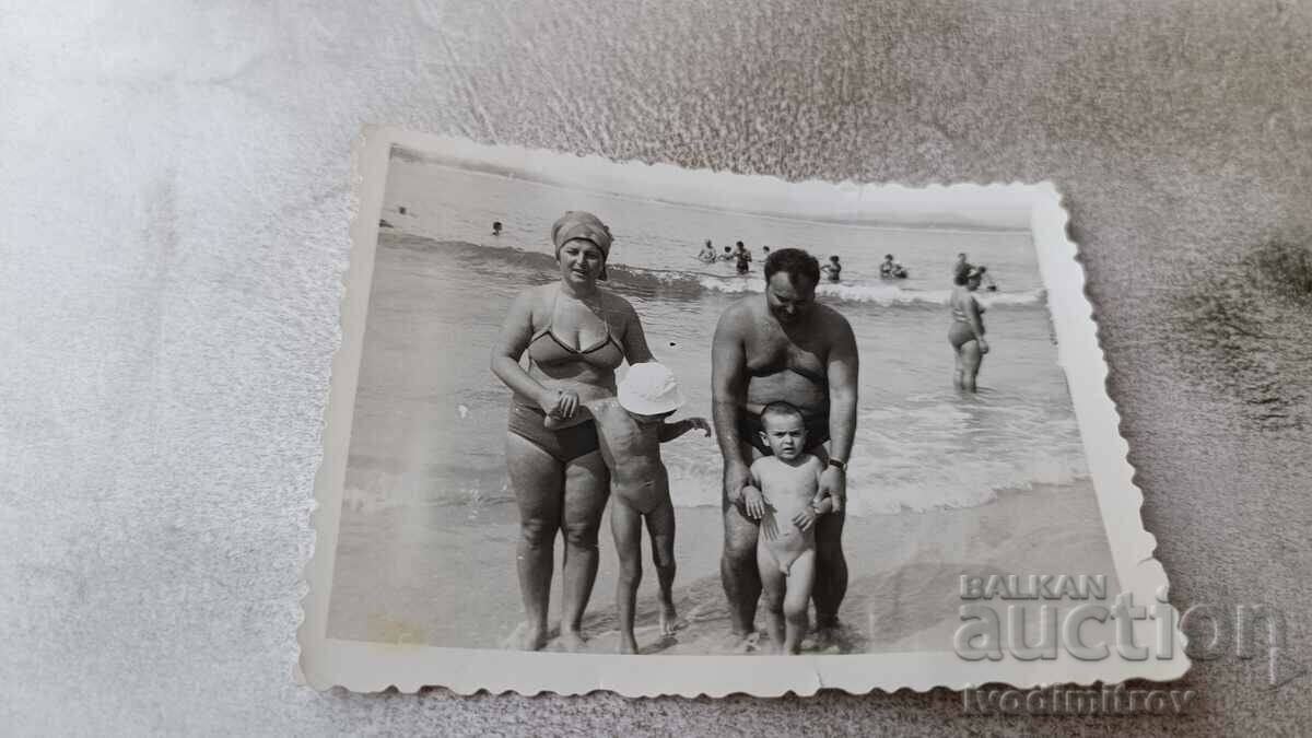 Fotografie Bărbat, femeie și doi copii mici pe plajă