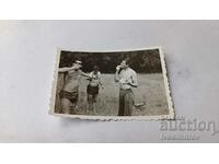 Снимка Трима мъже с къси панталони ядящи диня на поляна