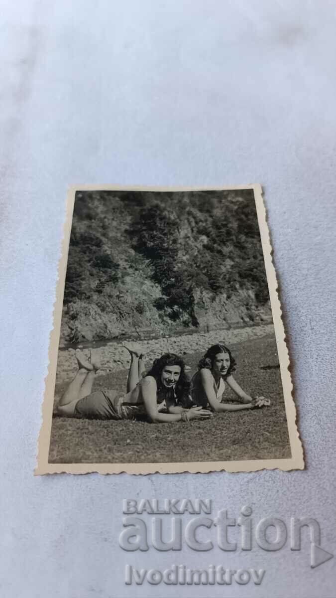 Fotografie Două fete tinere întinse pe iarbă