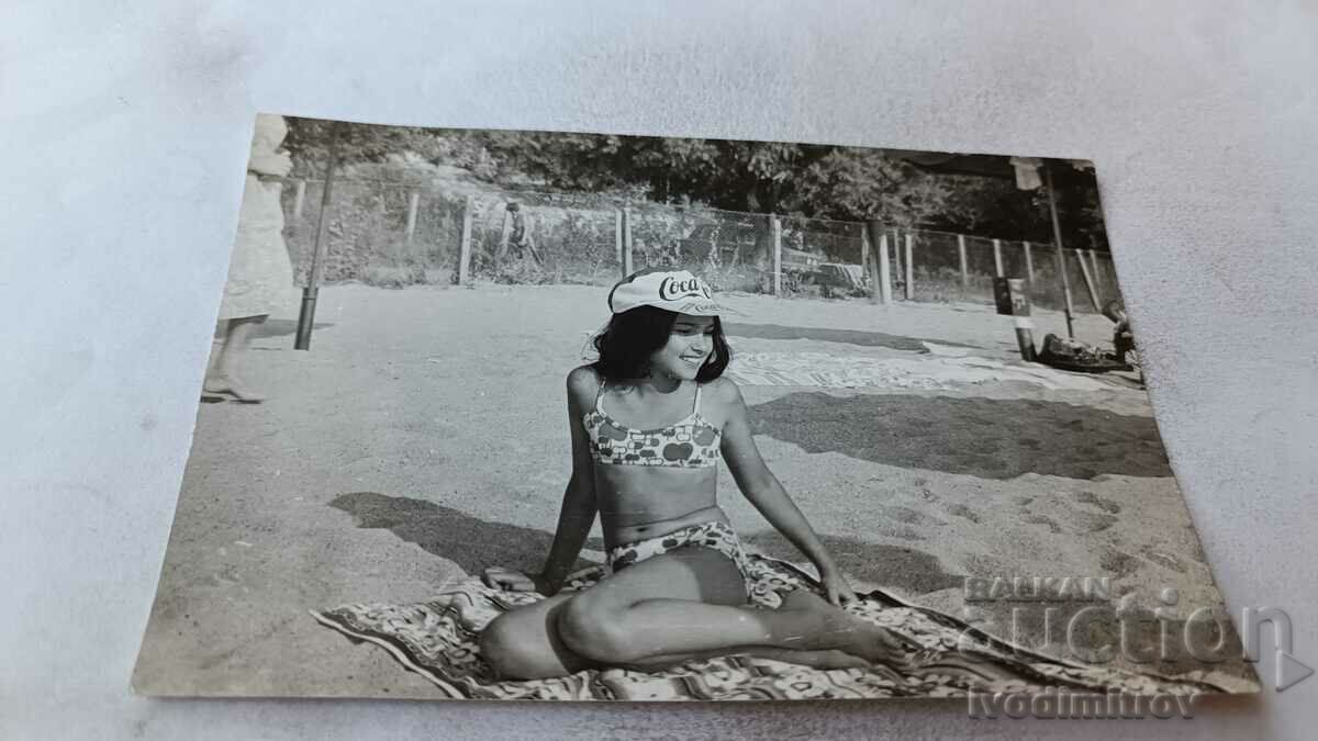 Fotografie Fată tânără cu o pălărie Coca-Cola pe plajă