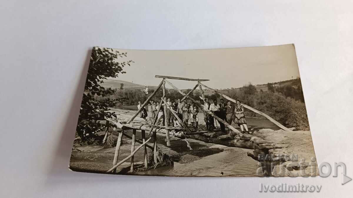 Снимка Мъже и жени на дървено мостче над река