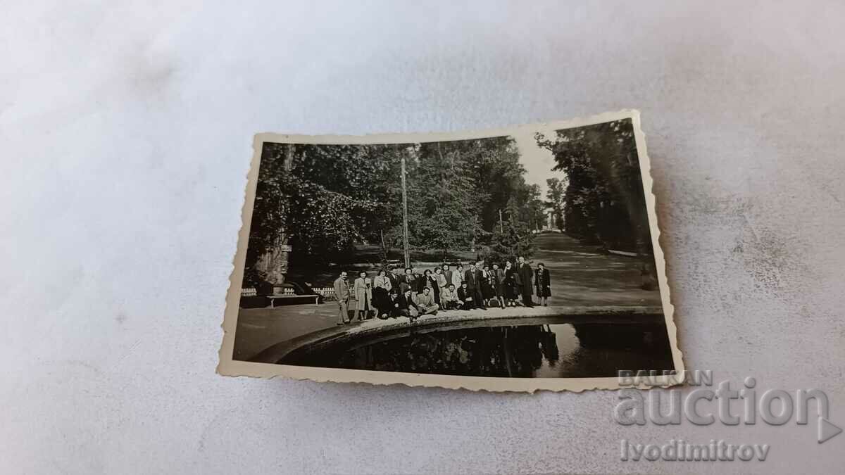 Fotografie Bărbați și femei lângă o fântână într-un parc