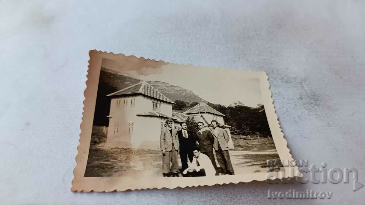 Foto Bărbați în fața unei cabane de munte
