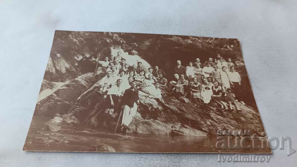 Photo Young men and women in front of a waterfall