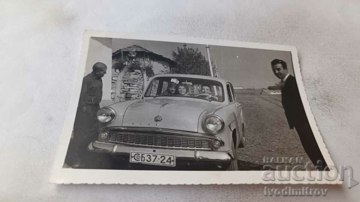 Photo Men and children in vintage Moskvich with reg. No. SfB 3724
