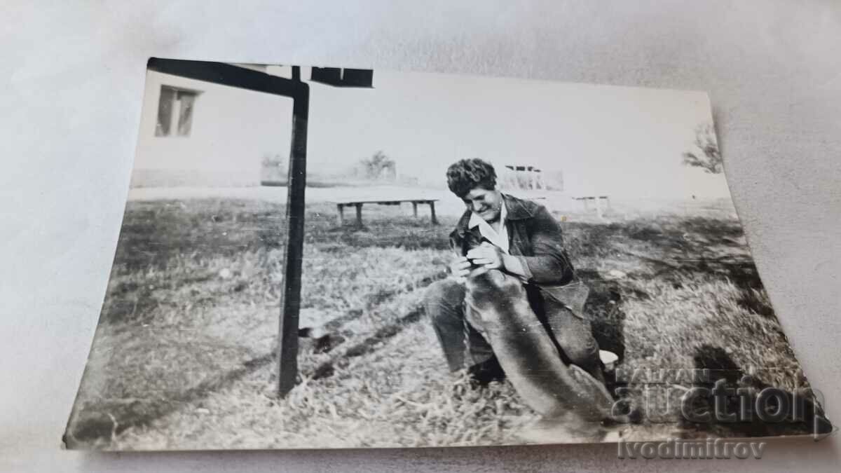 Photo Man stroking a tied dog