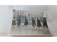 Φωτογραφία Νεαρά κορίτσια με λαϊκές φορεσιές που παίζουν χορό