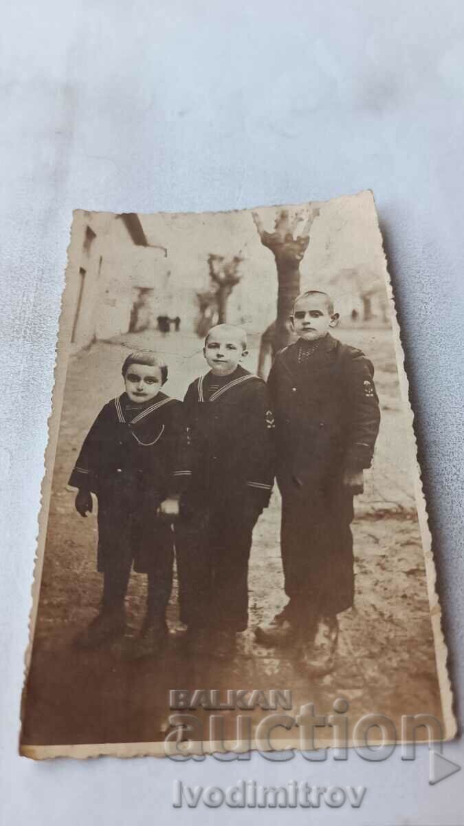 Photo Three boys as apothecary bottles on the street