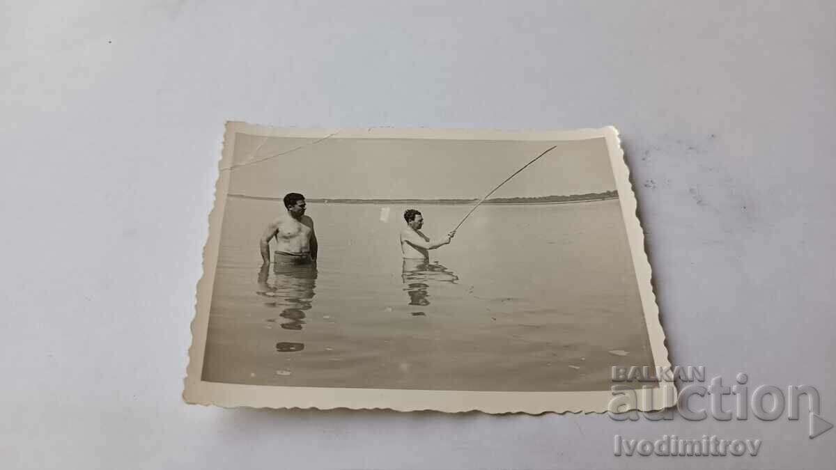 Picture Two men with a fishing rod in the sea