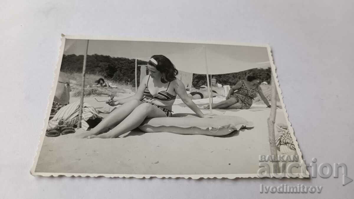 Φωτογραφία Νεαρή γυναίκα σε ένα στρώμα στην παραλία