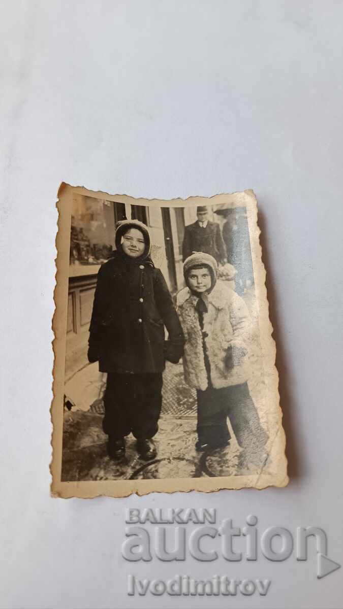 Φωτογραφία Σοφία Δύο παιδιά με χειμωνιάτικα παλτά στο πεζοδρόμιο