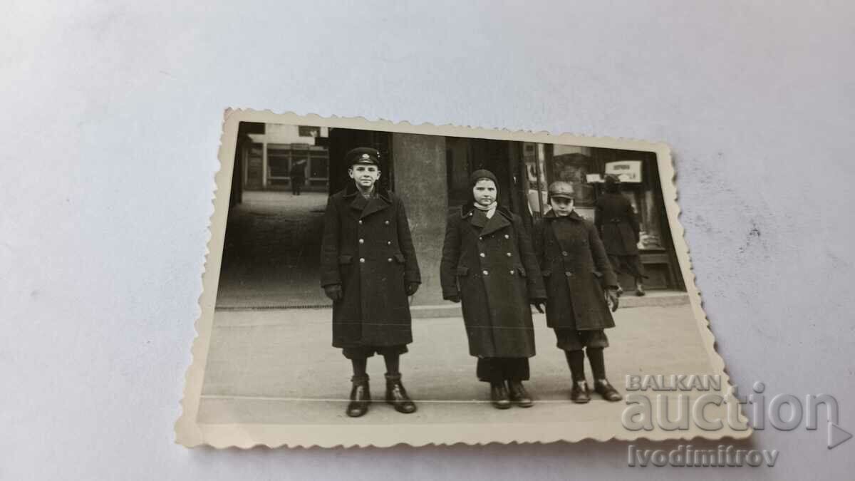 Ska Sofia Doi băieți și o fată în paltoane de iarnă pe trotuar