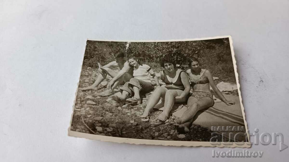 Photo Young man and three women on the grass