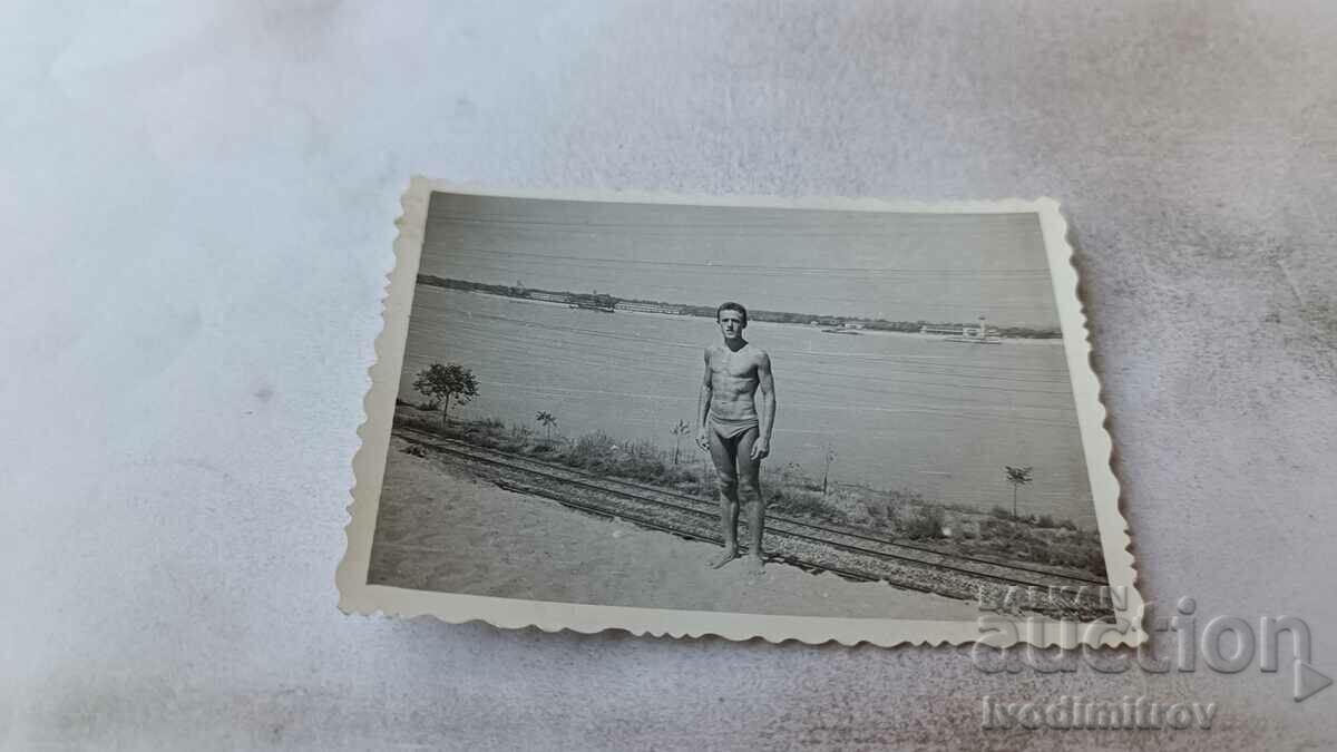 Φωτογραφία Άνδρας με μαγιό δίπλα στη θάλασσα