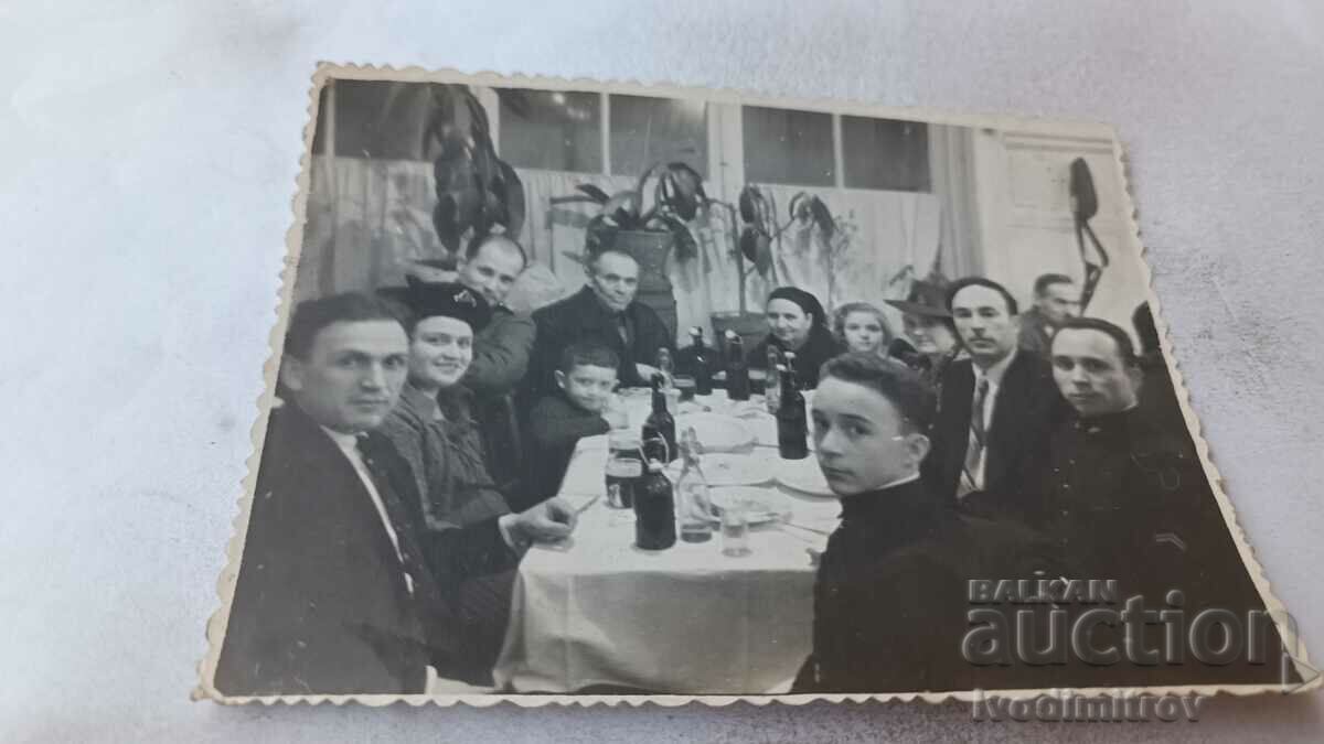 Imagine Bărbați și femei care beau la o masă
