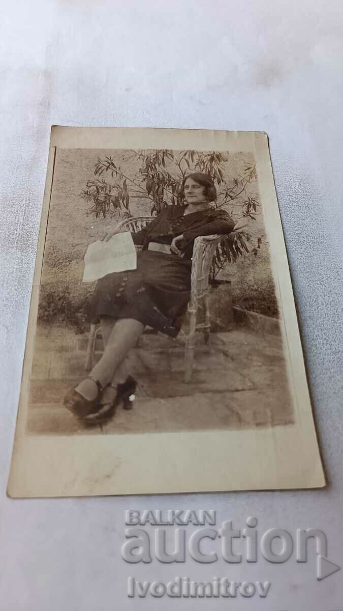 Снимка Жена седнала на плетен стол