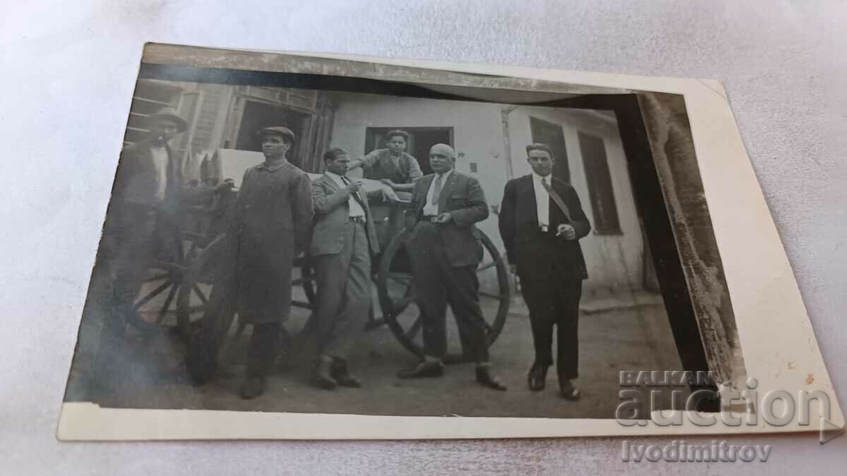 Foto Bărbați în fața unui cărucior