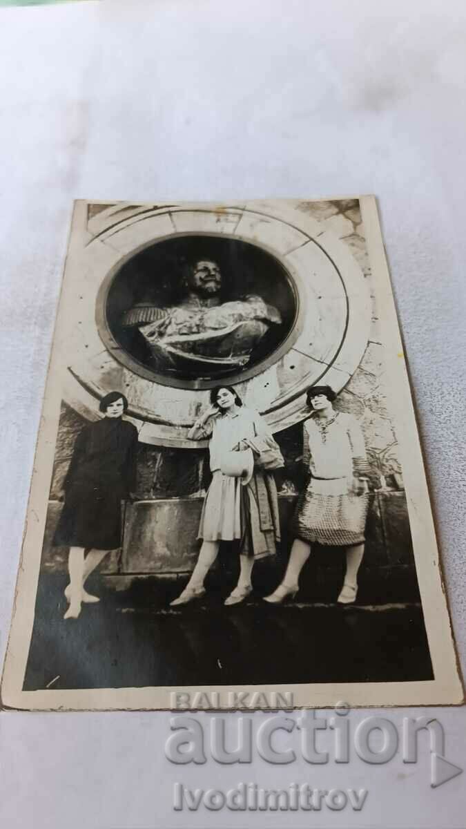 Φωτογραφία Τρία νεαρά κορίτσια μπροστά από μια προτομή του πρίγκιπα Μπάτενμπεργκ