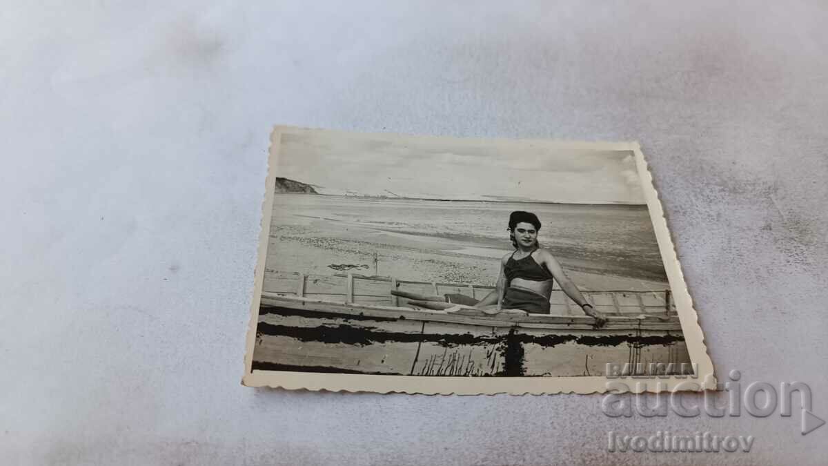 Photo Young girl sitting in a boat on the seashore