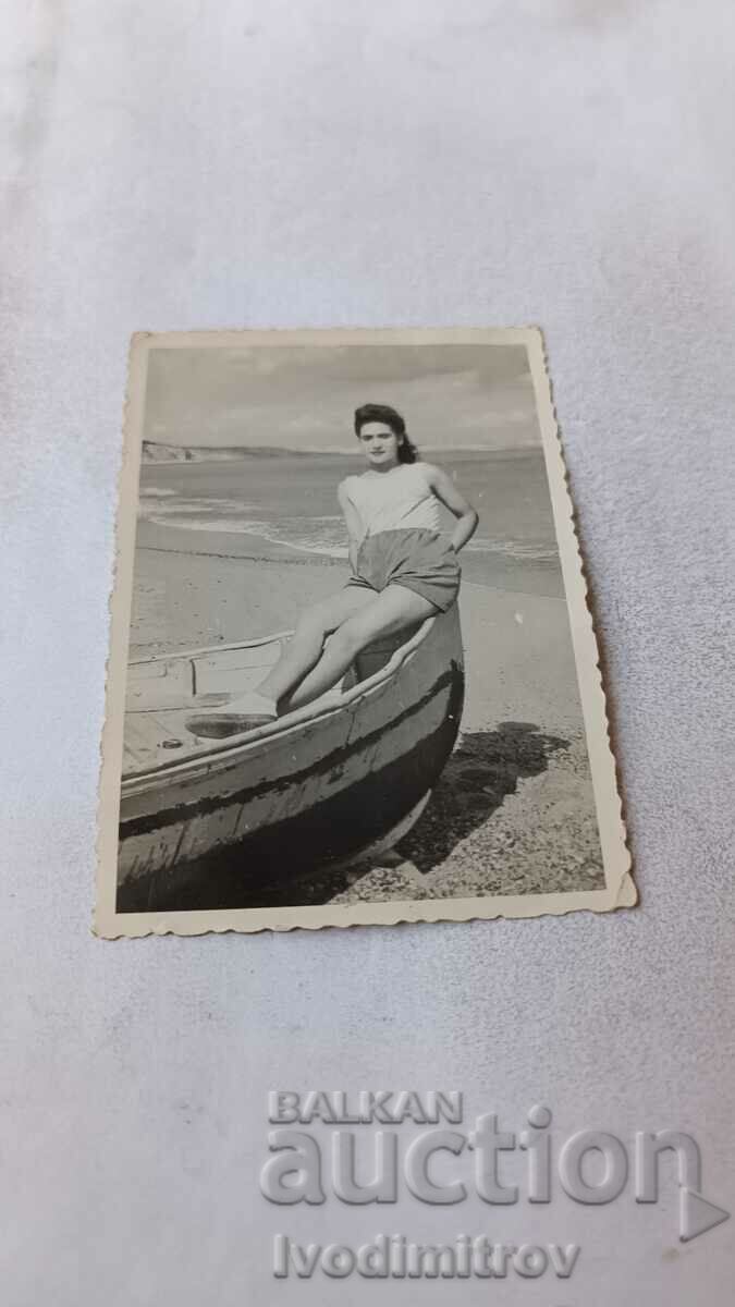 Photo Young girl sitting in a boat on the seashore