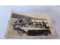 Photo Men women and children on a wooden platform in a lake