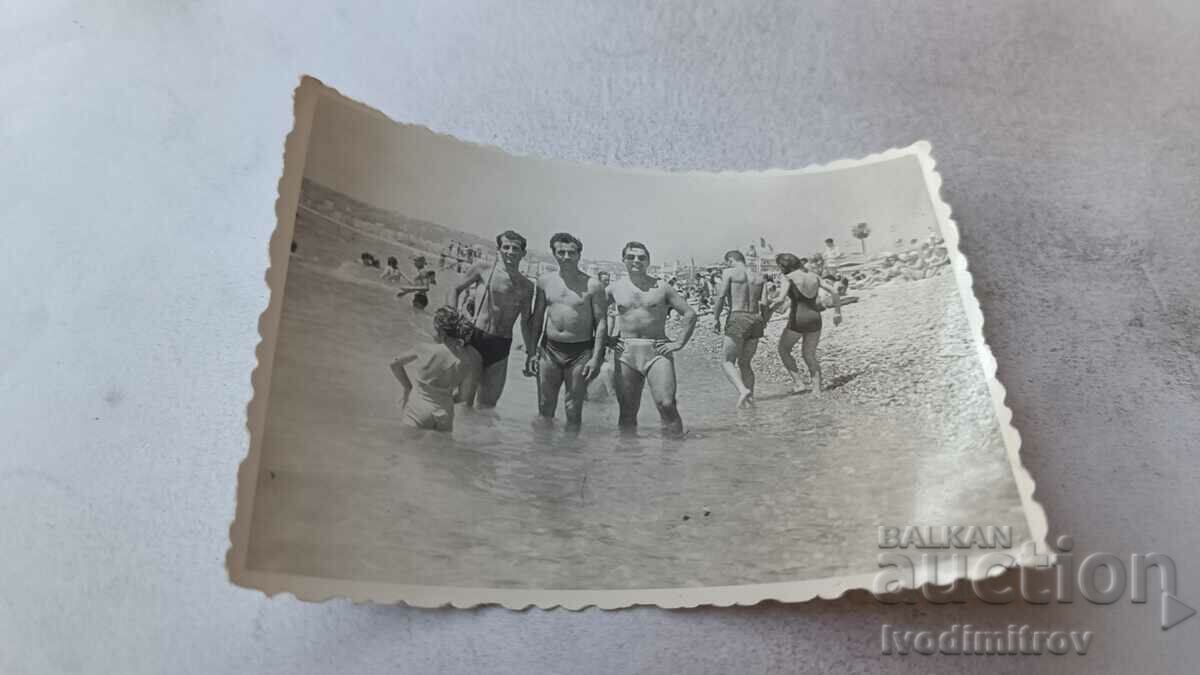 Foto Trei bărbați pe plajă