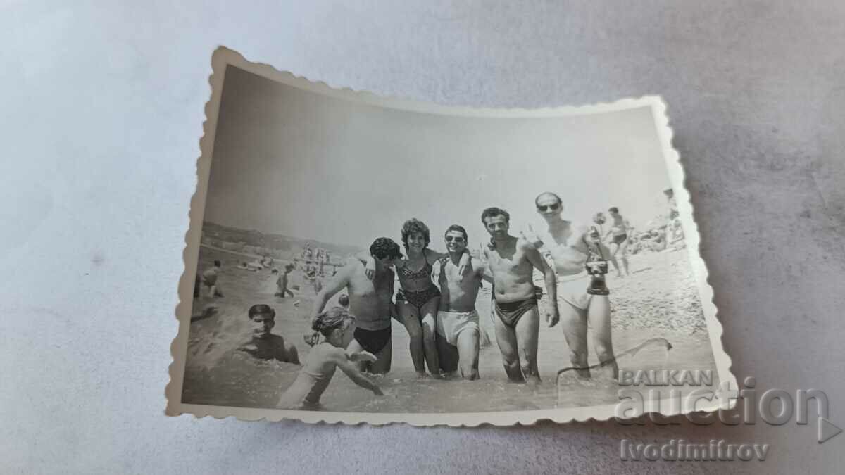 Fotografie Patru bărbați, o femeie și copii pe plajă