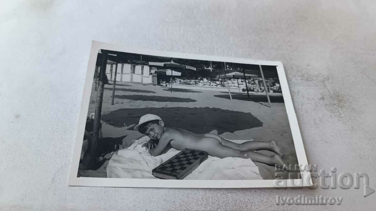 Photo Naked boy on a towel on the beach
