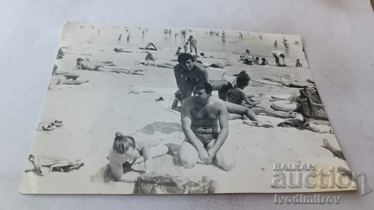 Foto Doi bărbați și o femeie pe plajă